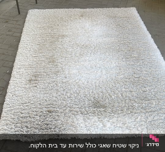 שטיח לבן מונח על מדרכה, חלקו נראה מלוכלך